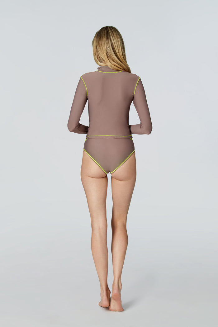 Rear view of woman modeling Sophie cropped jacket and Belle bikini brief in Taupe with neon piping