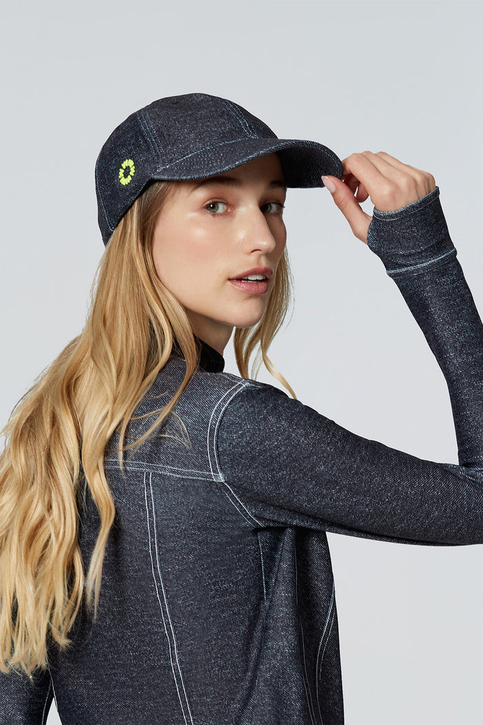 Woman modeling Watskin Billie baseball hat and matching long sleeved top in Black Denim