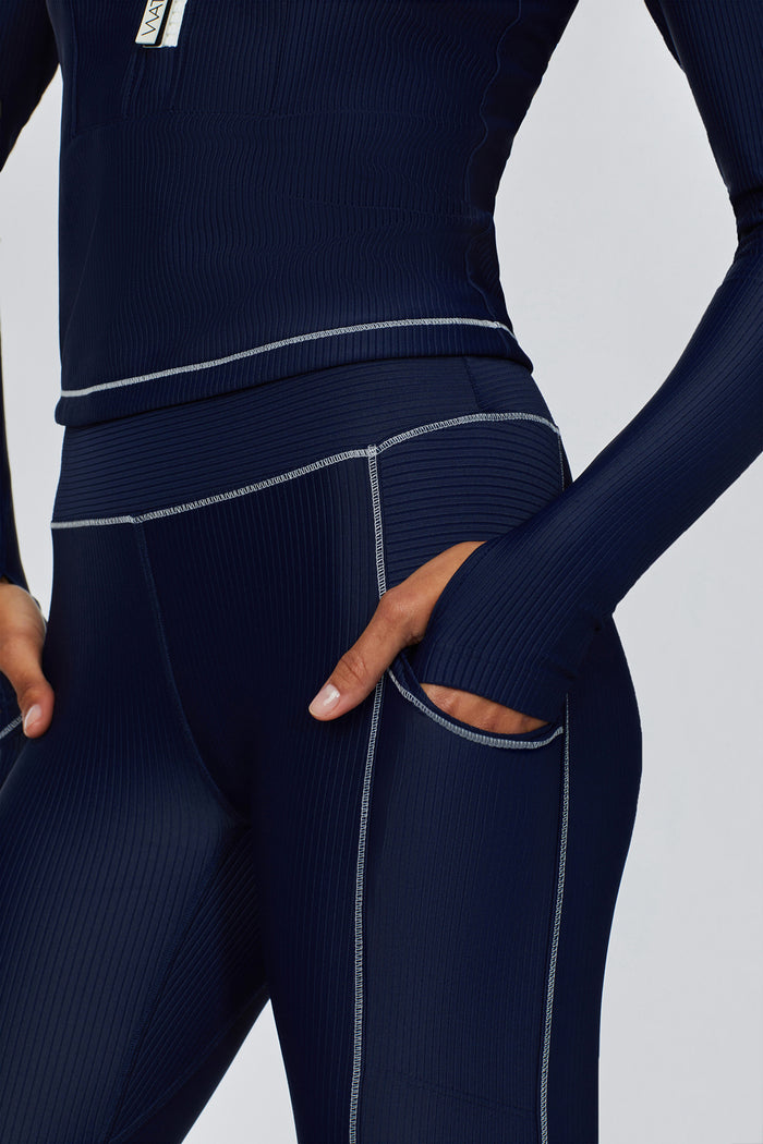 Close-up of female model wearing Watskin Brynn Ribbed Legging and Mia Long Sleeved Ribbed Tee in Marine Navy