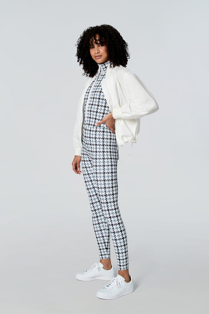 Woman modeling Watskin Chloe sleeveless catsuit in Gray Houndstooth with a white jacket