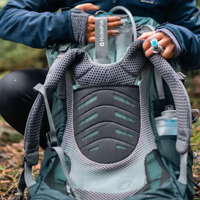 HydraPak Contour Clear Water Reservoir being inserted into a backpack, highlighting its ergonomic fit and hydration tube accessibility.  from  John Bull Clothing