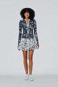 Woman in white tennis shoes wearing Watskin Ella bodysuit and Isabel tennis skirt in Black/White Floral