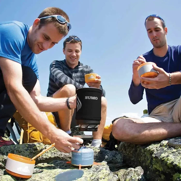 Group of hikers using Jetboil Sumo Carbon 1.8L Cooking System to prepare a meal outdoors. Ideal for group camping and backpacking trips.  from  John Bull Clothing