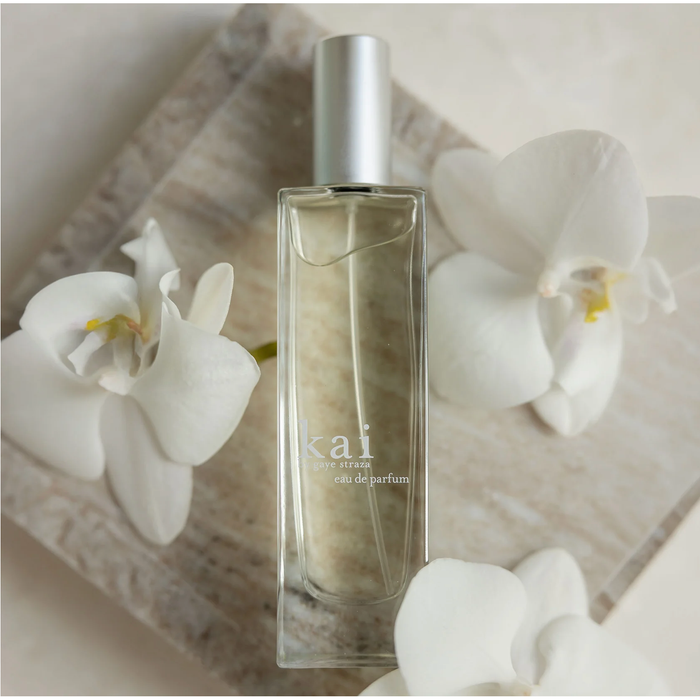 Perfume bottle labeled 'kai' with white flowers on a light background