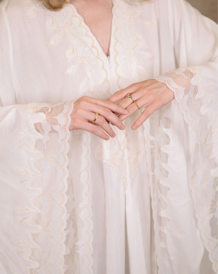 Close-up of the intricate lace detailing on the sleeves, showcasing the refined craftsmanship and feminine touch.