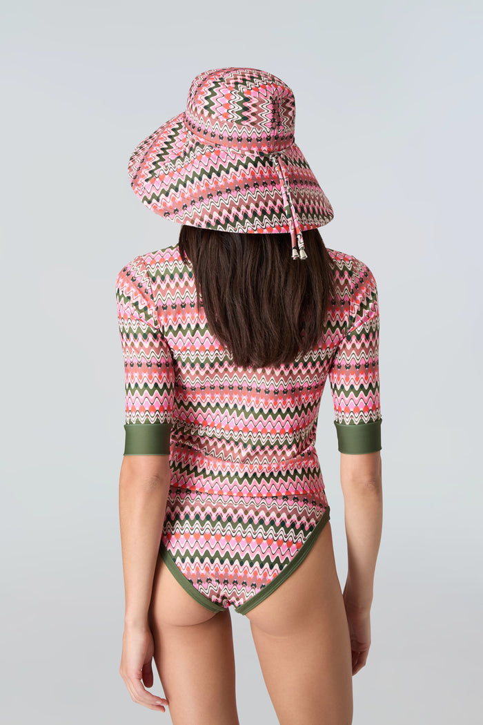 Back view: pink & green wavy stripe wide-brim hat, short-sleeve swim top, bikini bottom