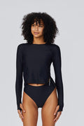 Model wearing Watskin Sasha long sleeve rash guard tee and high cut Belle bikini brief in Black