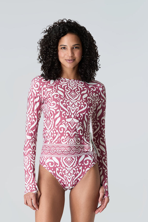 Woman wearing Watskin Sasha cropped tee and Belle bikini bottom in Dusty Rose Ikat against a gray background