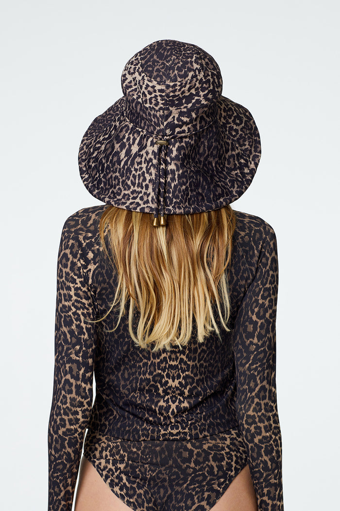 Rear view of female modeling Watskin Sienna Hat, Sasha rashguard and Belle bikini bottom in Leopard
