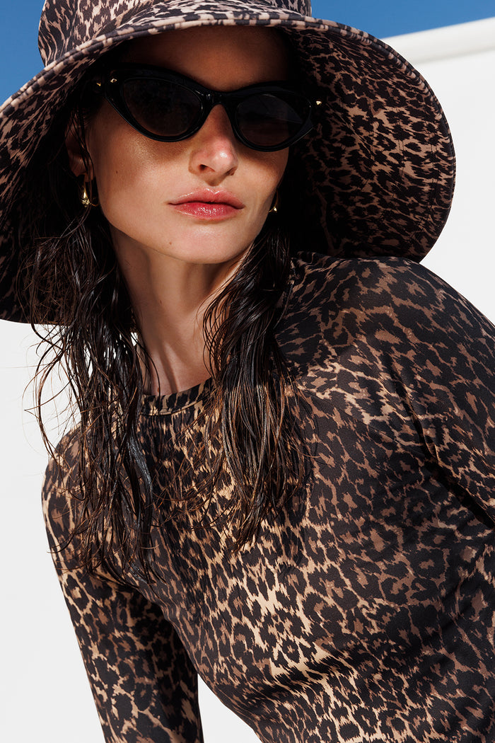 Female wearing sunglasses outdoors on a sunny day modeling Sienna sunhat and Sasha tee in Leopard
